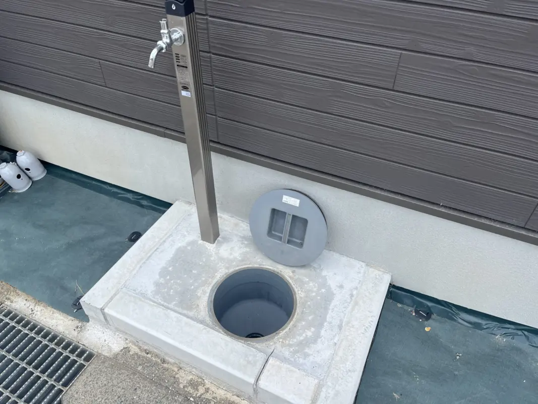 RVパーク GUNPAKU maebashi：建物の脇の水栓と、ふたを開けた地面の口