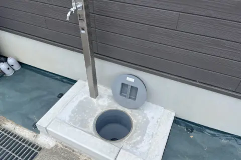 RVパーク GUNPAKU maebashi：建物の脇の水栓と、ふたを開けた地面の口